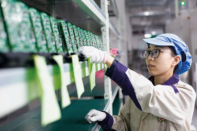 江苏一家公司的车间内,工人正在生产用于出口的电梯信号系统电子产品